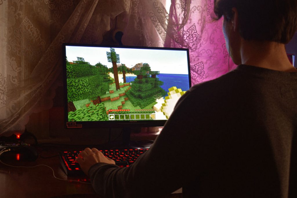 Young man playing roblox on pc desktop