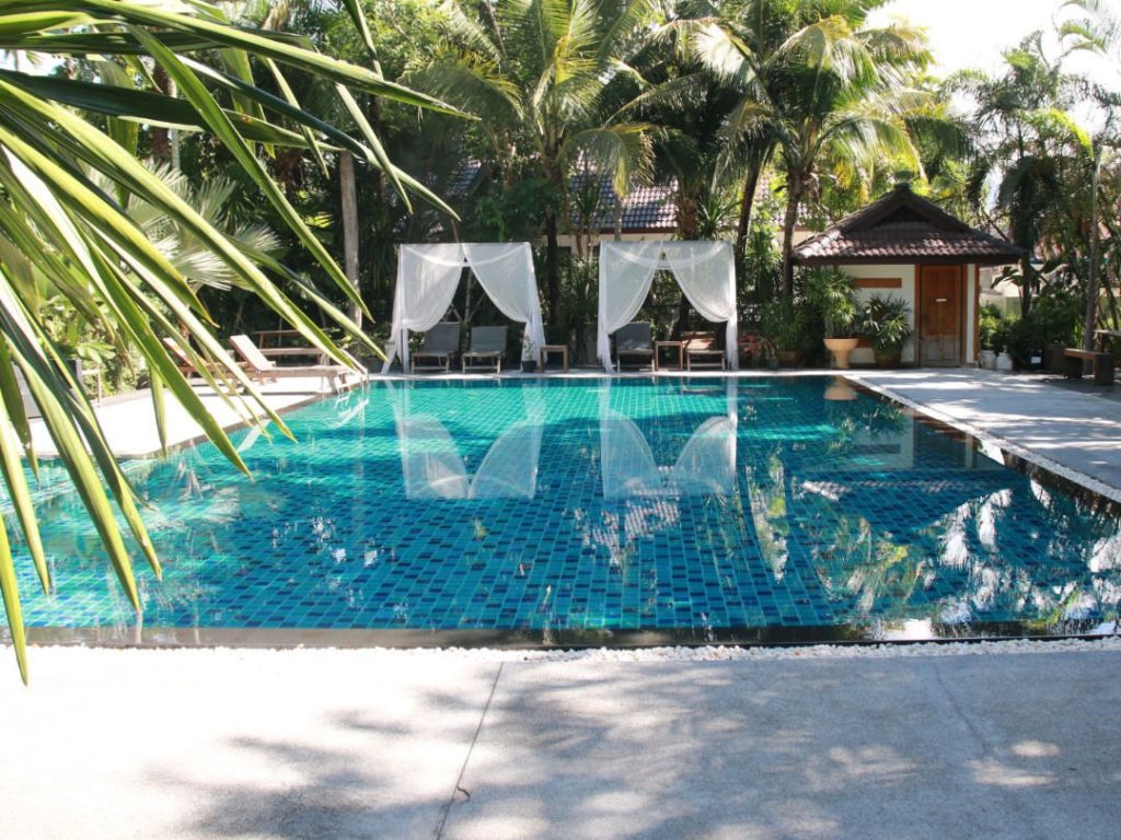 Swimming pool with shaded sun loungers at One Step Rehab