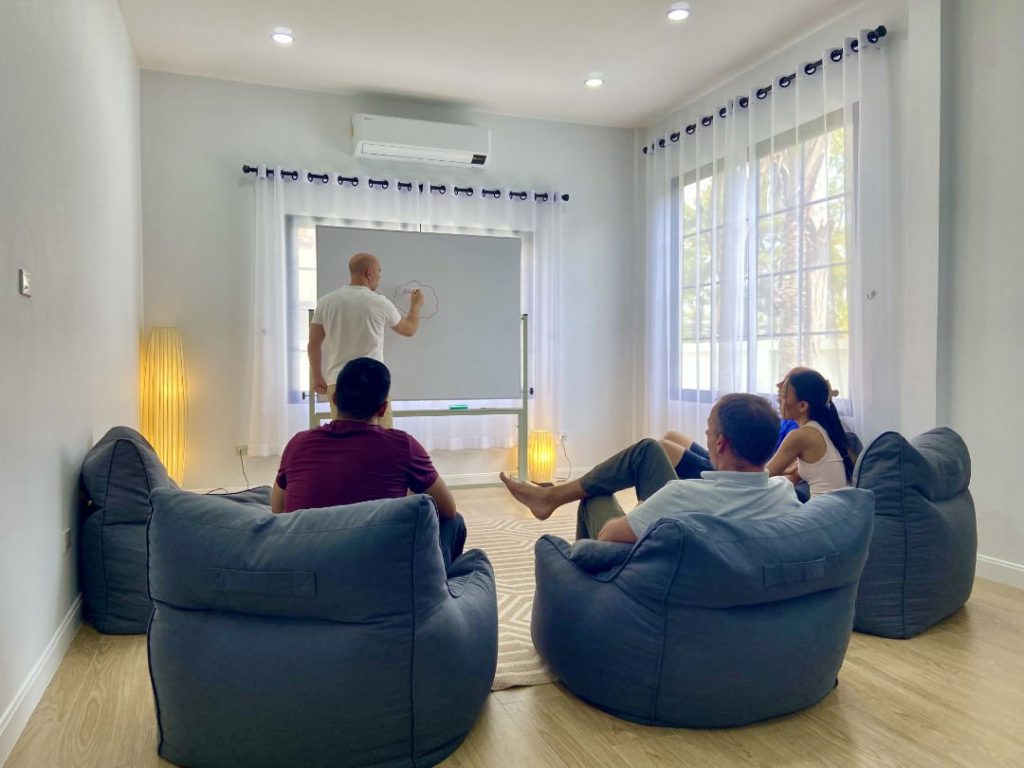 Thai rehab residents watch head counselor discuss 12 steps treatment program