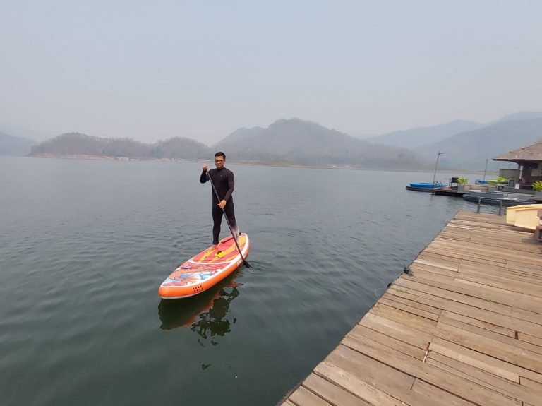 Paddle boarding on lake surrounded by himalayan foothills