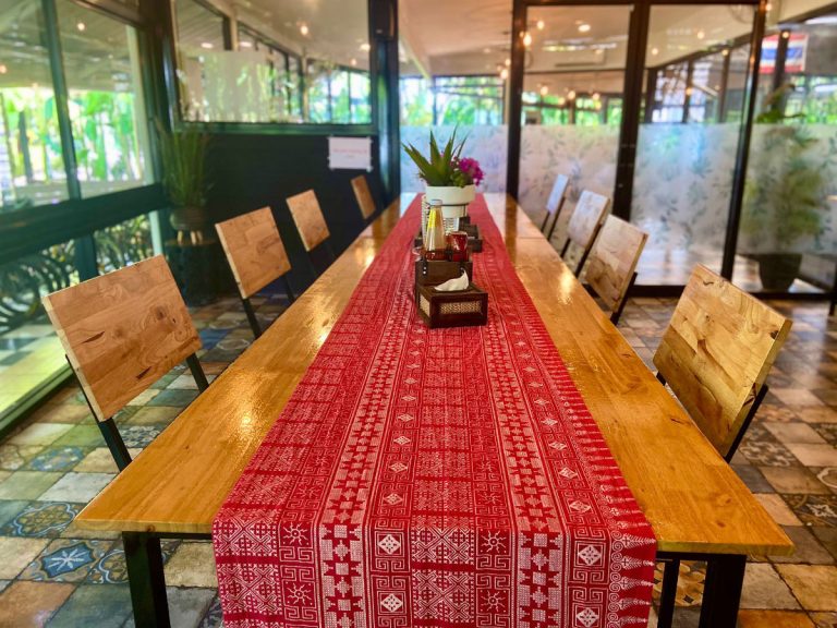 Long wooden dining table in air conditioned restaurant