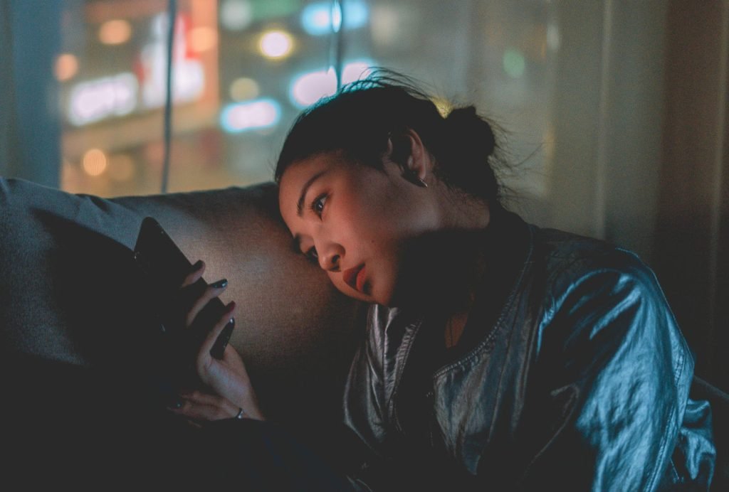 Woman stares at phone in lonely appartment