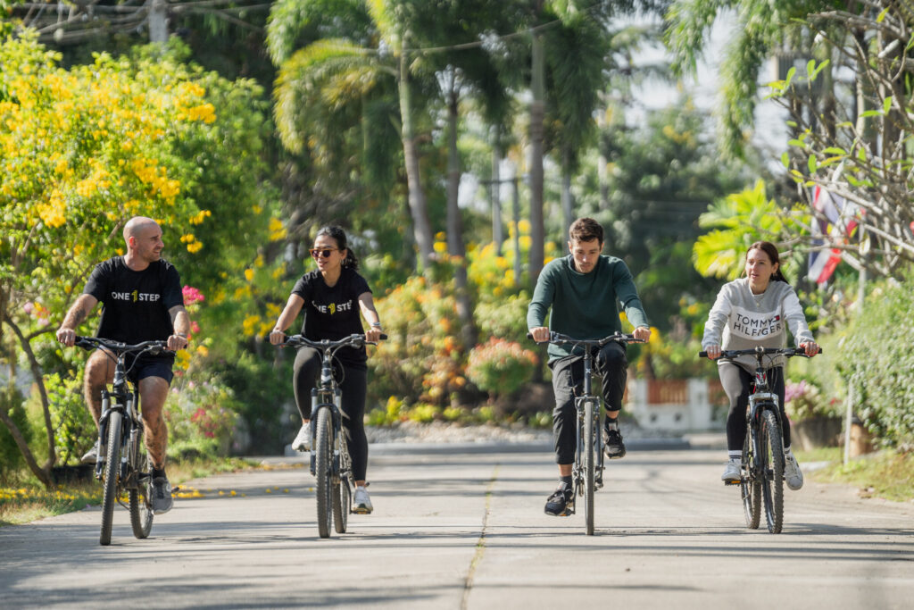 Group cycling through Chiang Mai countryside at One Step Rehab