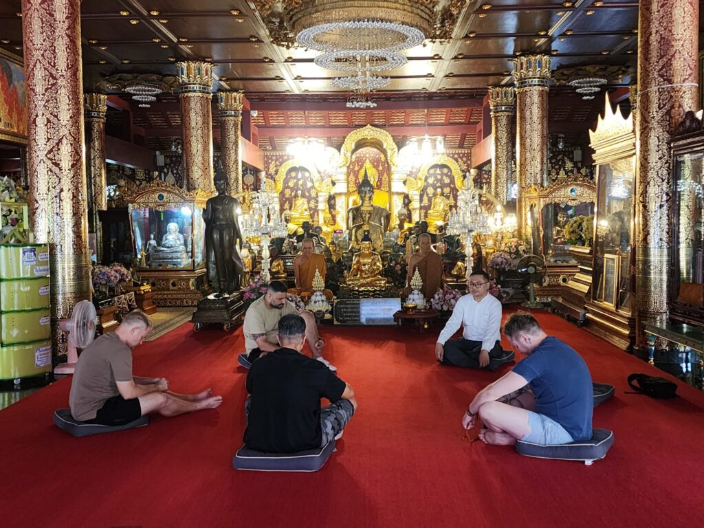 Clients sitting inside an ornate Buddhist temple